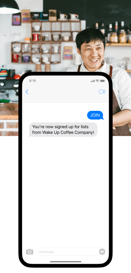 A smiling small business owner with an apron at a coffee shop. 
